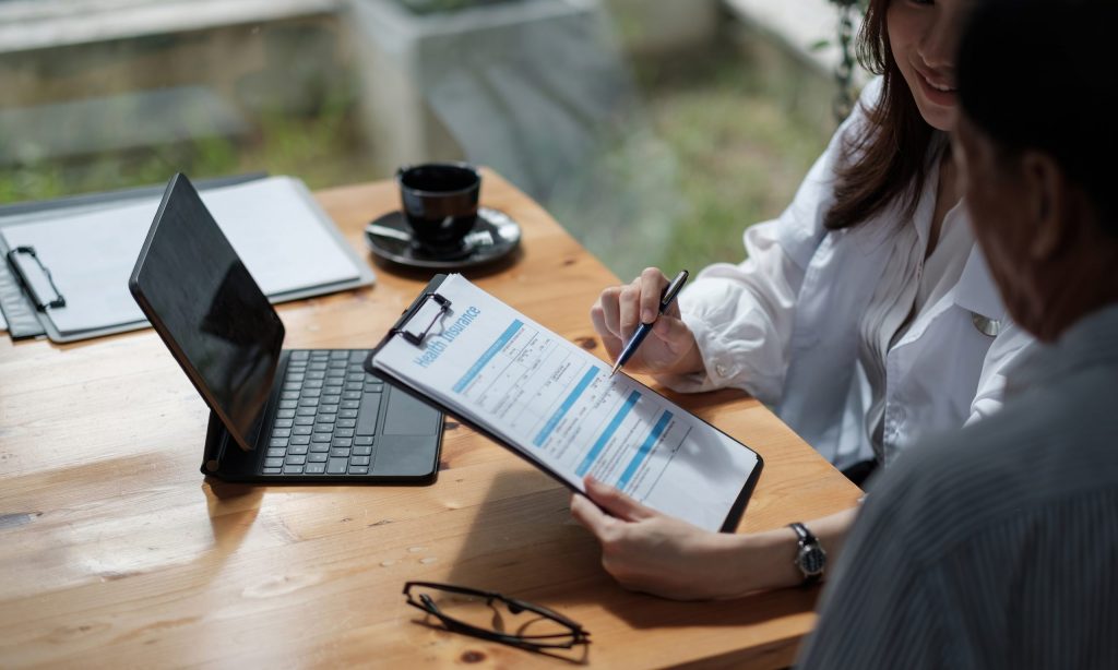 person filling out insurance forms for addiction treatment