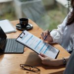 person filling out insurance forms for addiction treatment