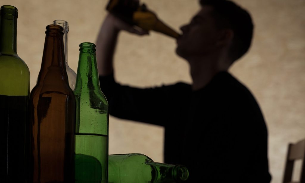 man binge drinking alcohol