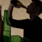 man binge drinking alcohol