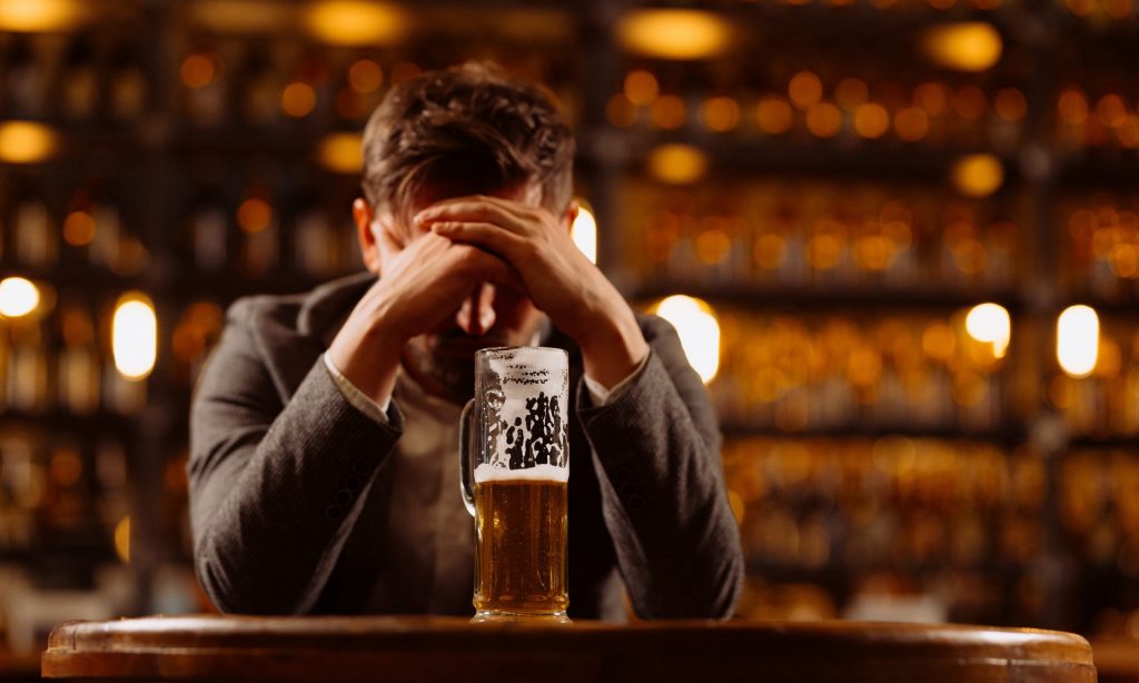 man with anxiety drinking