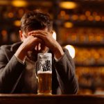 man with anxiety drinking